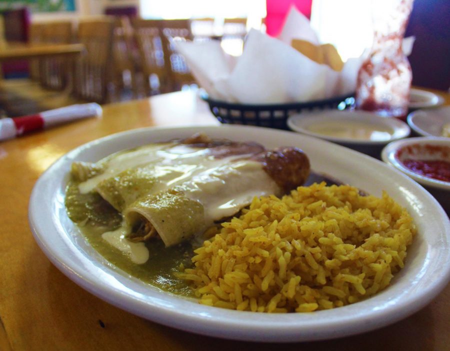 A+variety+of+enchiladas+lay+on+the+table%2C+smothered+in+tasty+sauce