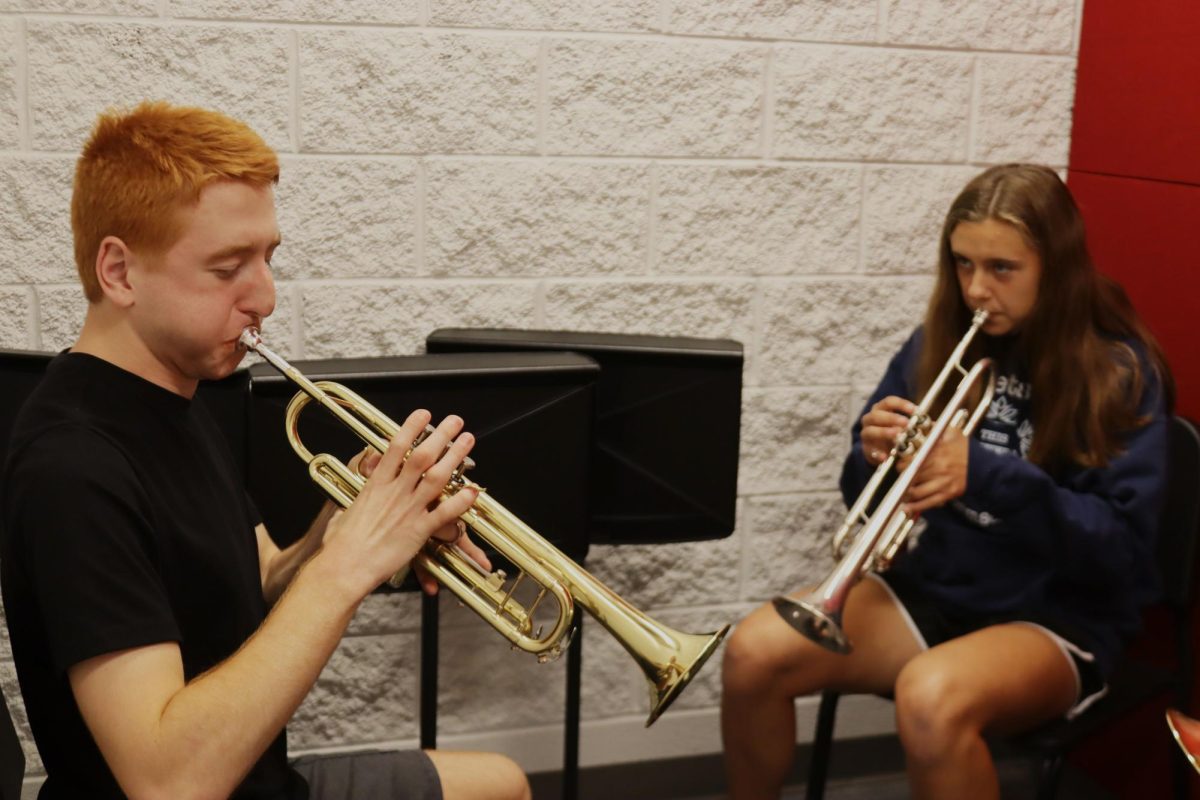 Senior+Tyler+Gustin+plays+the+trumpet+with+mentor+Adelyn+Janssen+in+one+of+the+practice+rooms.