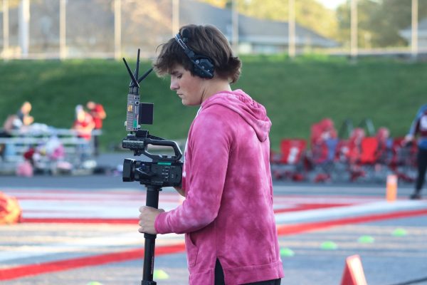 Sophomore Henley Dougan watches the viewfinder to ensure he gets the perfect shot for Nixa Live viewers.