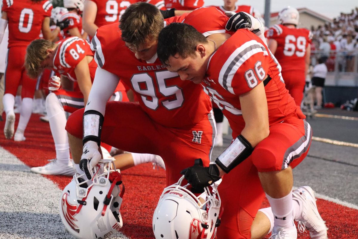 Junior Dylan Johns (left) and senior Tyler Swanson join together in prayer before playing a football game.
