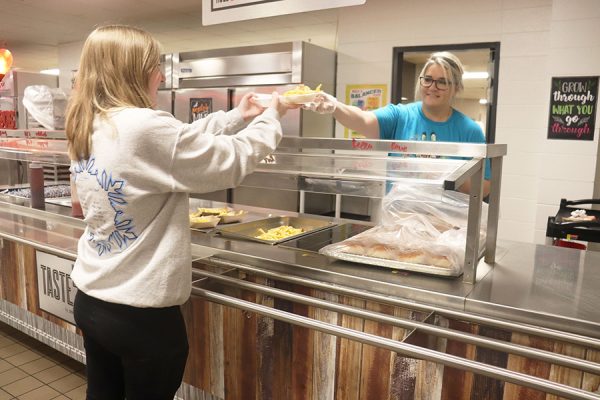 Kitchen manager Kari Smith serves lunch to sophomore and SNAC member Claire Newberry. “Nutrition is very key for a student throughout the day for learning and alertness and study,” Smith said. 

