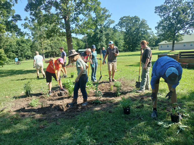 Contributors at GLADE summer camp dig holes for new vegetation.