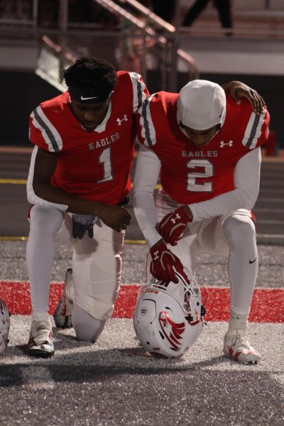 Brothers Keivon Flint (12) and Randy Flint (11) kneel in prayer before a game against Joplin High School.
