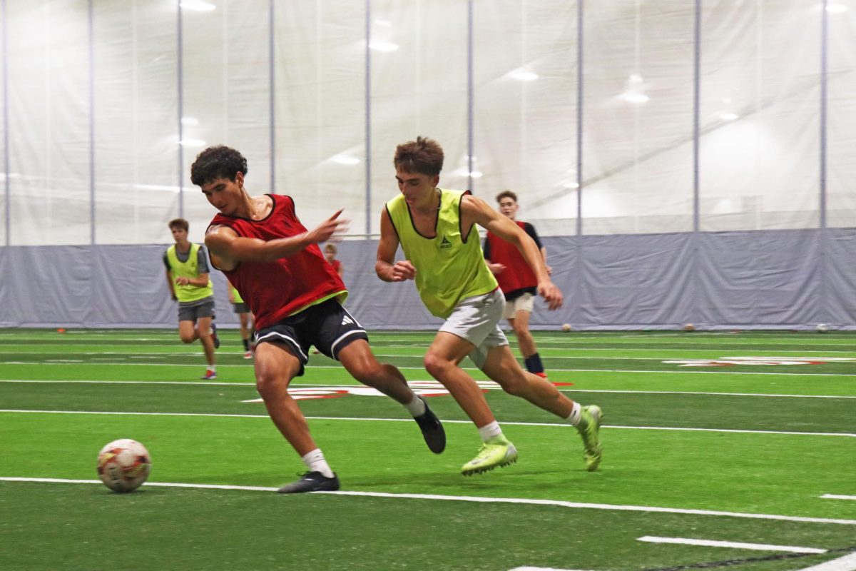 Senior Conner Shaar and junior Jackson Lutzke fight for the soccer ball at soccer practice in the Apex. “If it's raining, we'll practice outside unless it's just either pouring, thunder or lightning,” Evan Palmer, head soccer coach, said.