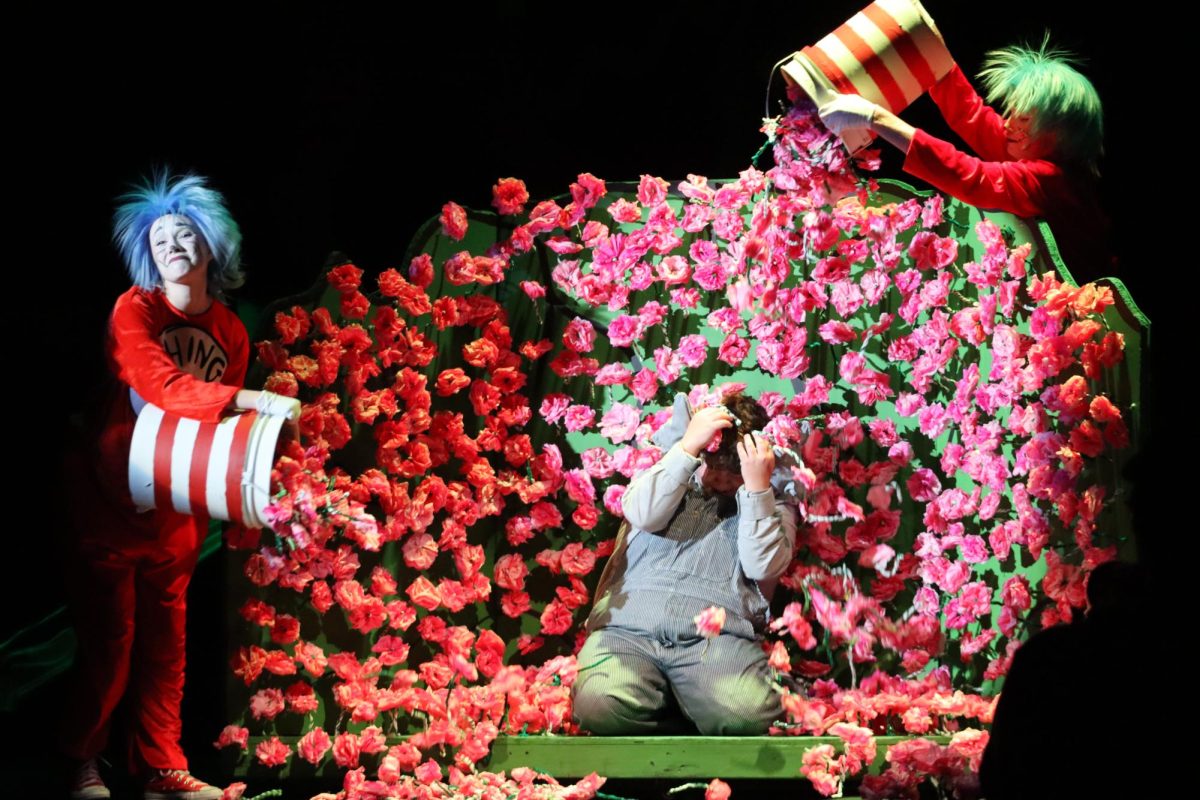 Thing 1 [junior Carter Snyder] and Thing 2 [junior Josefina Brown] dump clovers over Horton [junior Judah Anderson] as he searches for the Whos in a field full of clovers in “Seussical the musical”.
